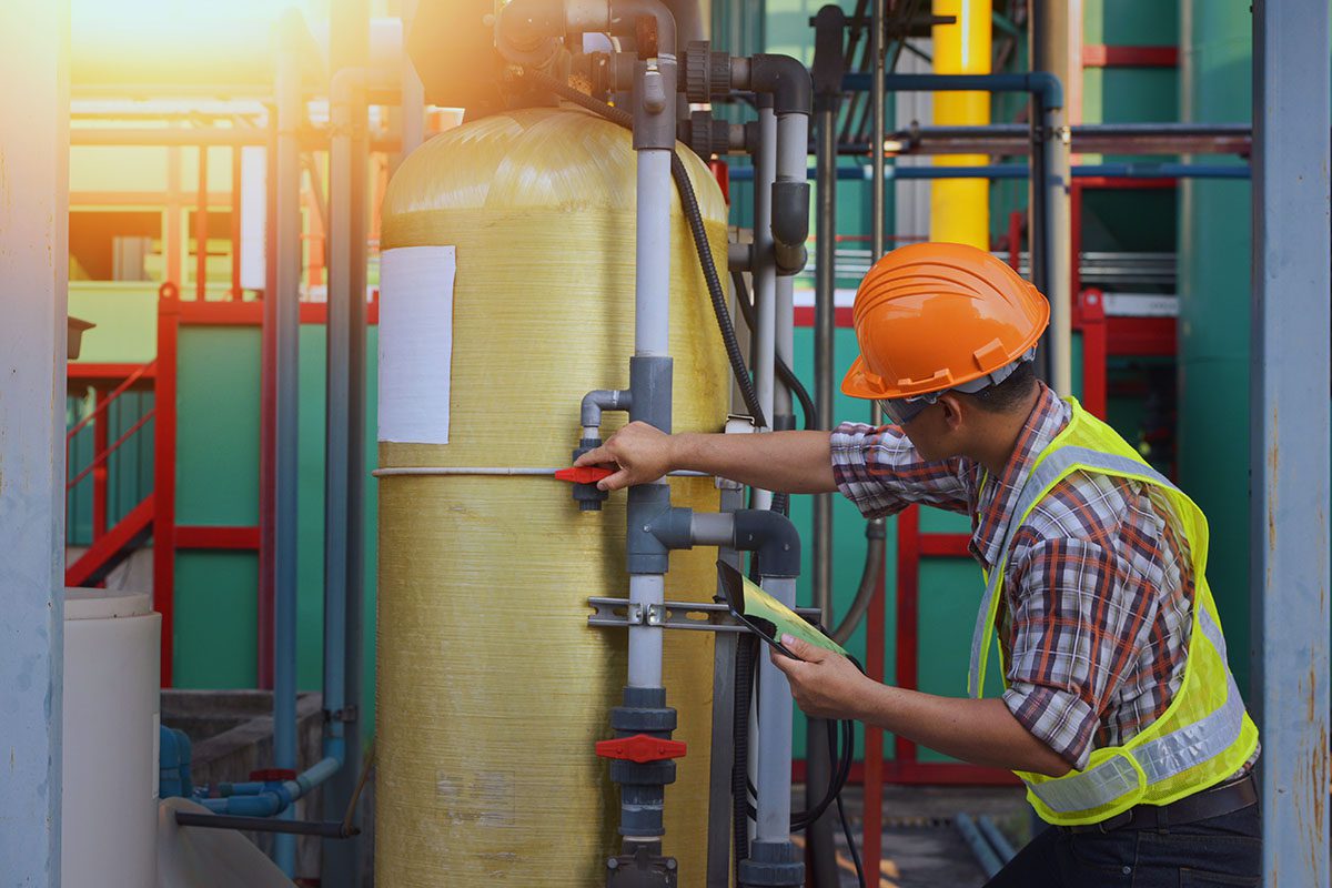 Ingeniero industrial revisando expediente técnico de seguridad de máquina con planos y esquemas