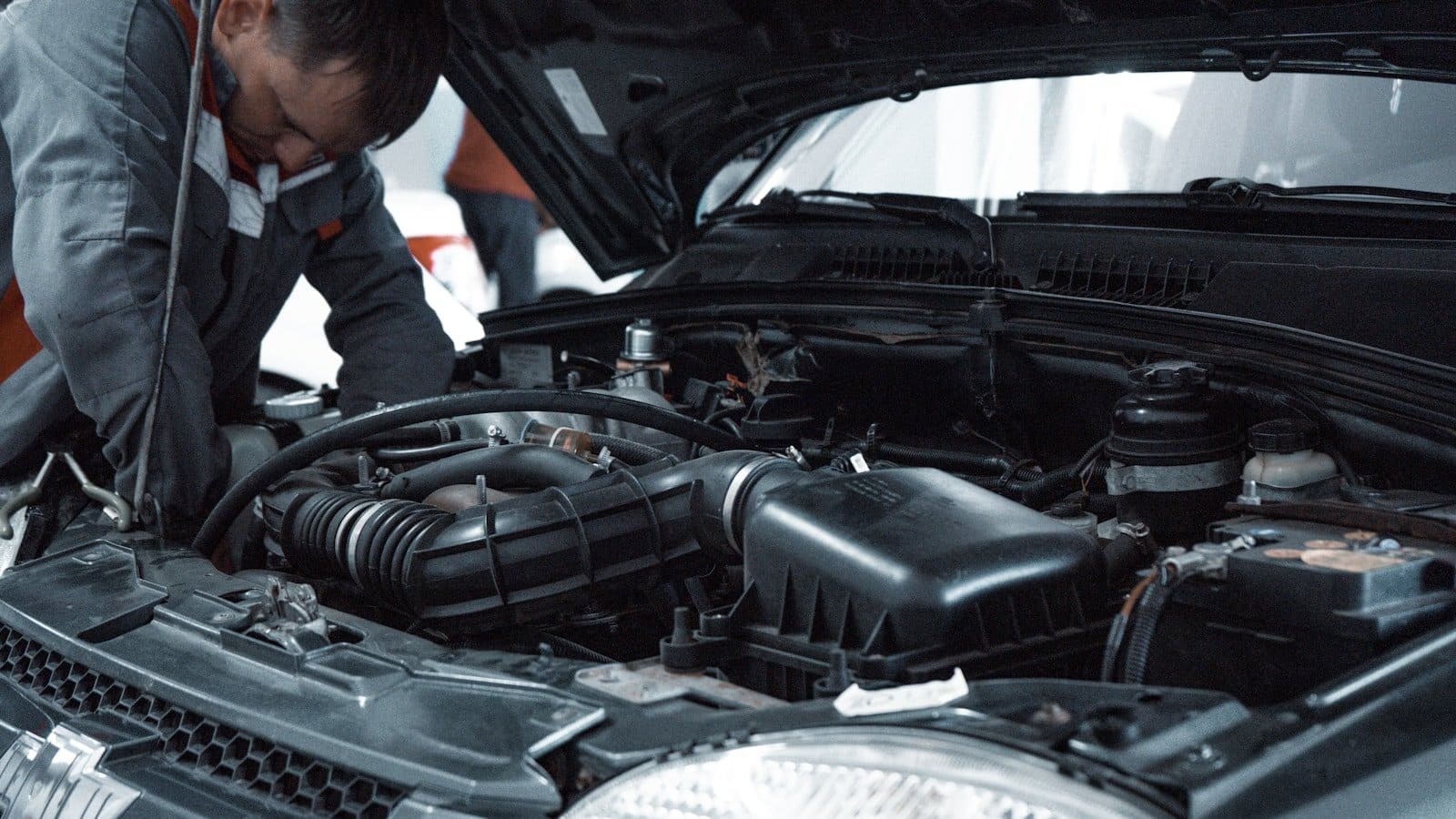 Ingeniero técnico inspeccionando motor de vehículo para expediente de homologación