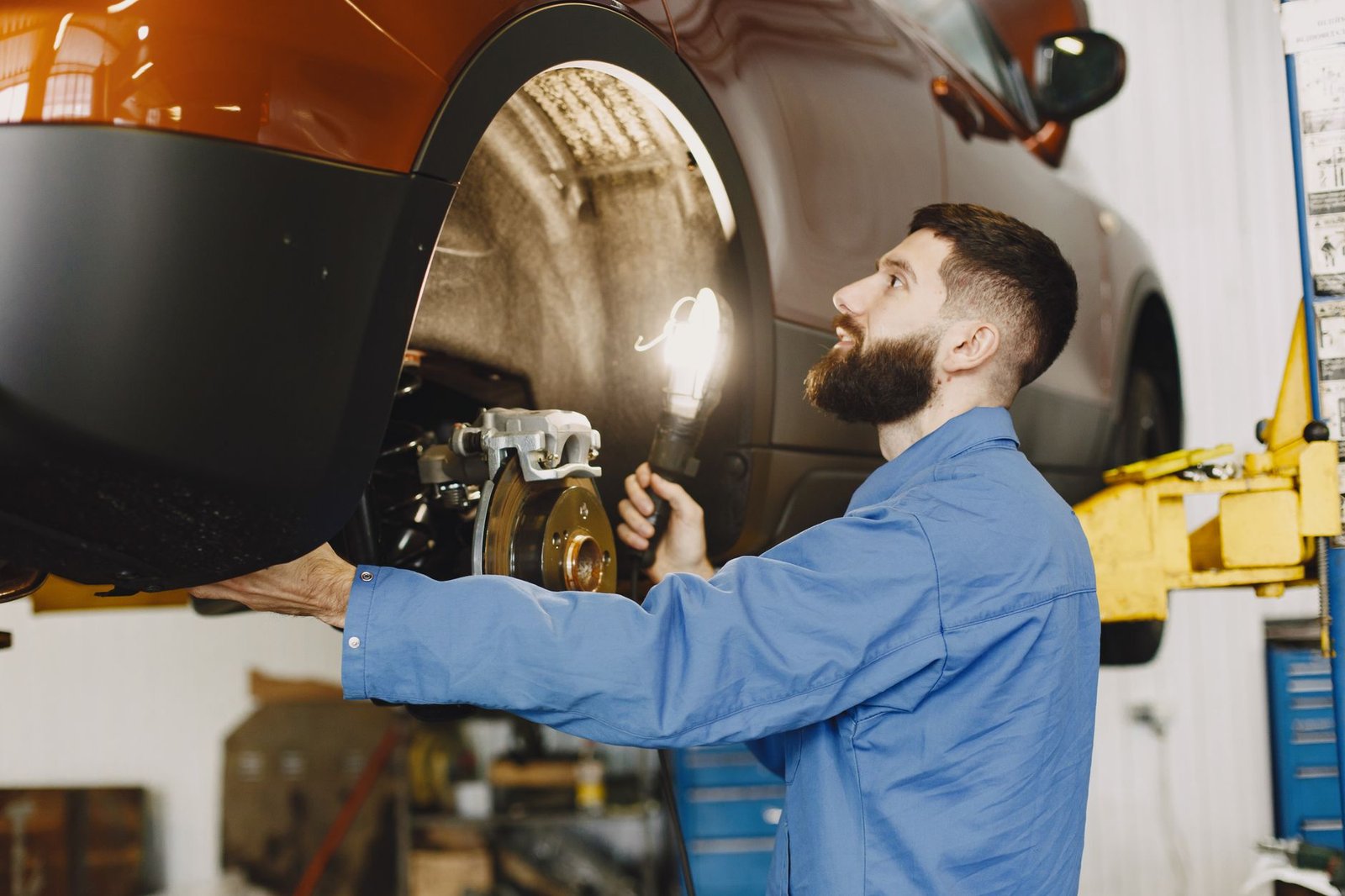 Técnico revisando sistema de frenado en línea de inspección de vehículos