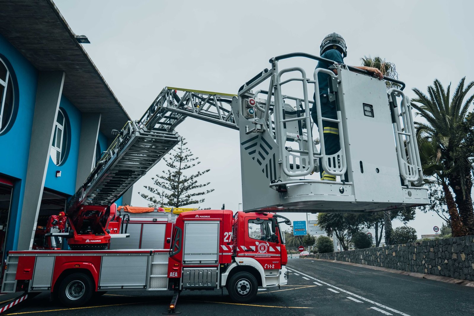 Plataforma elevadora montada sobre furgón con estabilizadores desplegados en nave industrial
